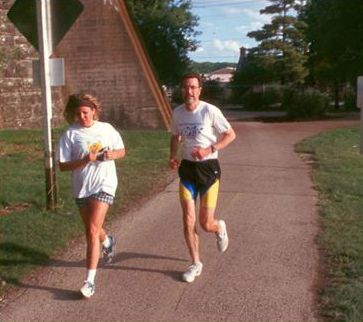 The picture shows a male and female adult jogging on a shared use trail.