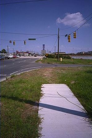 The last picture is of a busy roadway with sidewalk that ends in the grass about 20 feet short of the entrance to an entrance ramp onto a freeway. There is no crosswalk.