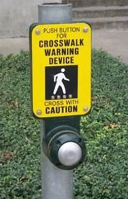 The picture on the left shows a close–up view of a pushbutton and supplemental plaque that says "PUSH BUTTON FOR CORSSWALK WARNING DEVICE – CROSS WITH CAUTION". 