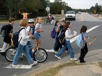 Picture shows a group of eight children crossing a street.