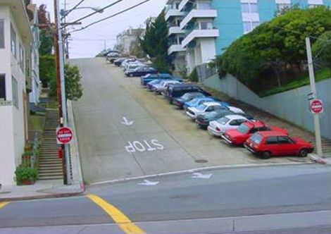 This picture shows a street on an extremely steep hill. Steps are used along the street in place of the sidewalk.