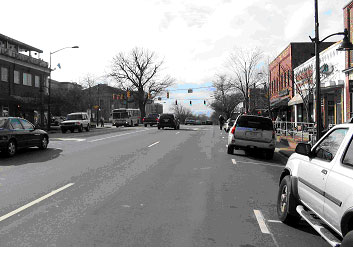 Figure 27. Photograph. Street view of bicycle example 3. This is one of three photographs of the same intersection. This picture, from the street level, shows a four-leg, signalized intersection of two roads. The main approach road is a four-lane road with a separate left-turn lane approaching the intersection and parallel onstreet parking on both sides of the street. The crossing street is a four-lane road with separate left-turn lanes.