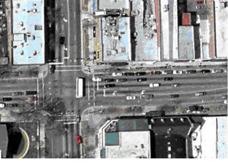 Figure 29. Photograph. Overhead view of bicycle example 3 (image courtesy of the United States Geological Survey). This is an aerial view of the same intersection as in Figures 27 and 28. An arrow pointer marks the approach to the intersection from the east.