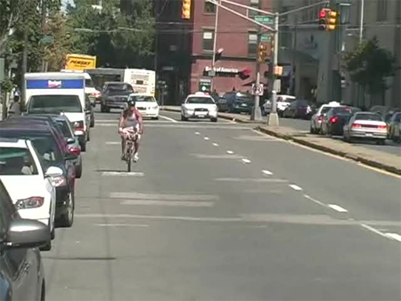 Photo. Bicyclist riding over the sharrows. Click here for more information.