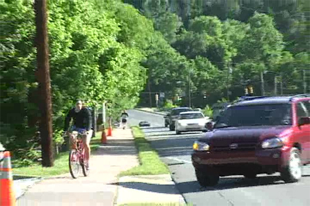 Photo. Bicyclist interaction with motor vehicle at driveway. Click here for more information.