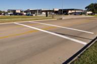 This photo shows the transverse markings installed at the study site on Agronomy Road. The markings consist of two parallel white transverse lines that are each 12 inches wide. There is 8 ft between the two strips.