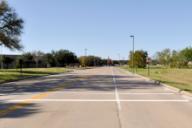 This photo shows the transverse markings installed at the study site on Discovery Drive. The markings consist of two parallel white transverse lines that are each 12 inches wide, with 8 ft between the two strips.