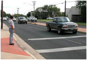 In this example of poor opportunity, a pedestrian cannot find an acceptable gap due to high traffic volume. The pedestrian is waiting on the sidewalk at the uncontrolled crosswalk, but several cars are advancing toward the crosswalk.
