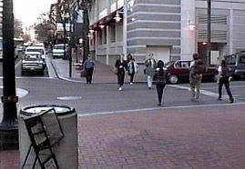 Queued turning vehicles waiting for a gap in a pedestrian stream in Portland, Oregon.