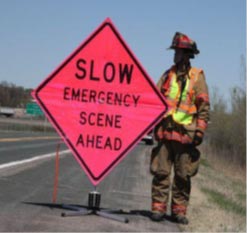 Fireman standing next to an emergency road sign