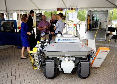 The RABIT bridge deck assessment tool is shown in the photograph. Five people are standing behind it having a conversation.