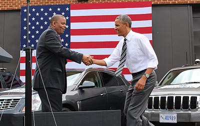 U.S. Secretary of Transportation Anthony Foxx shakes hands with President Obama outside of the Saxton Laboratory Test Vehicle Garage at Turner-Fairbank Highway Research Center. 