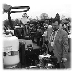 Photo of Mark Alpert inspecting crack-sealing equipment