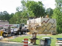 Researchers performing load tests on a block of geosynthetic reinforced soil.