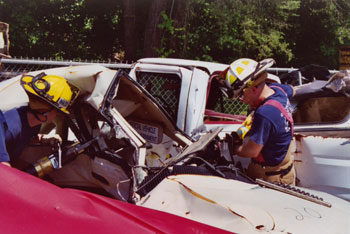 Firefighters removing door from damaged vehicle