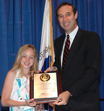 Acting Deputy Secretary of Transportation Kirk Van Tine is shown presenting a plaque to Taylor Morgan Cunningham