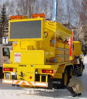 a snowplow with a dynamic message signa dn additional lighting attached to the back of the vehicle