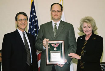 FHWA Administrator Mary E. Peters and Associate Administrator for Research, Development and Technology Dennis Judycki, director of the TFHRC, present an Administrator's Awards to Raymond Krammes