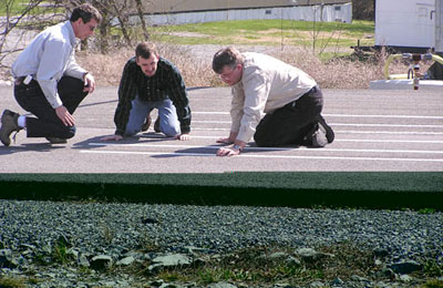 Representatives and staff from FHWA, VDOT, and VTTI closely examine and compare different pavement markings