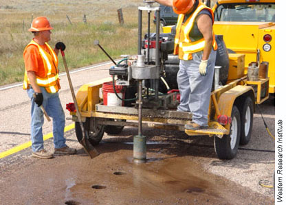 Workers drill out road core samples