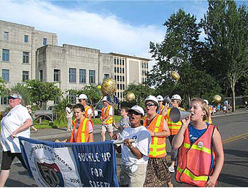 FHWA employees, family, and friends are shown participating in  the Lakefair parade in Olympia, WA, as part of WSDOT and FHWA's celebration of the anniversary.