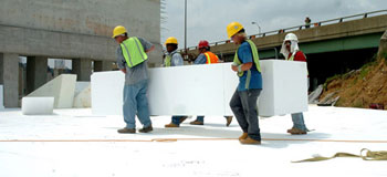 Workers are shown moving a block of EPS geofoam, a lightweight fill alternative, into position for construction of a ramp embankment at the  Woodrow Wilson Bridge  project. - Photo Credit: Paul Arch, NOVA Chemicals