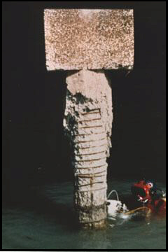 Diver conducts a video inspection of a badly deteriorated concrete pile.