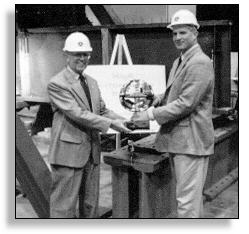 R&D Associate Administrator Bob Betsold and Research Engineer Bill Wright pose with the CERF award in the lab where the high-performance steel is being tested.