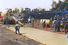 Workers pour and finish a thin (65 mm) section of UTW overlay at TFHRC's Pavement Testing Facility