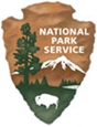 NPS Logo, which is the shape of an arrowhead pointing downwards. There is a bison at the bottom of the logo and a snow-capped peak in the background. It says, "National Park Service" in white letters above the peak.