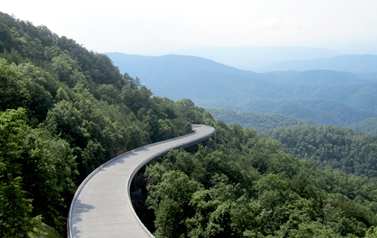 This is an overhead photo of the Foothills Parkway bridge. The bridge is a winding viaduct around the edge of a mountain slope.