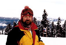 This is a photo of Mike Jones wearing a jacket and ski goggles while standing on a snowy ski slope in Zermatt, Switzerland.