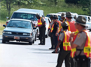 Photo showing officers conducting safety belt enforcement during a highway checkpoint.