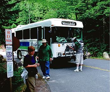 Photo showing a passenger removing his bicycle from the front of the bus.