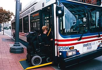 Photo showing a woman in a wheelchair entering a bus.