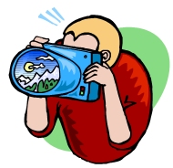 Cartoon drawing of a blonde man in a red shirt taking a photo of a scenic mountain range.