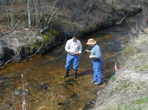 Two members of the scan team inspect the source of water to the Jumping Run Mitigation Bank site in NC while standing in the shallow stream.