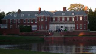 A photo of the Allerton Park Conference Center, a large red brick building, in Monticello, Illinois.