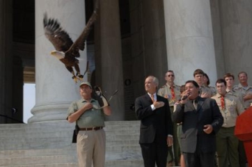 Caption: Phot of Secretary of Interior Kempthorne and ceremony participants look on as Challenger, a bald eagle used in educational programs, flies during the ceremony.  Photo courtesy of U.S. Fish and Wildlife Service.