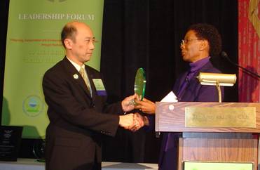 King Gee accepts the Green Highway Program Leadership Award for his enthusiastic support of the FHWA’s involvement in GHP efforts.  The award was presented by Gloria Shepherd, Associate Administrator of Planning, Environment, & Realty, at a ceremony held on January 15, 2008, in Washington, D.C.  