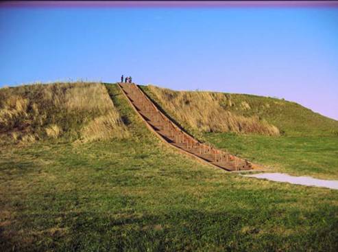 Photo of workshop participants on a field trip to Cahokia Mounds State Historic Site. They are standing on the top of a hill and seen from a distance.
