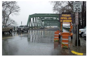 Image of a two-lane steel bridge on a rainy day.