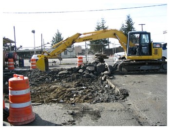 Photo of a backhoe clearing rubble.