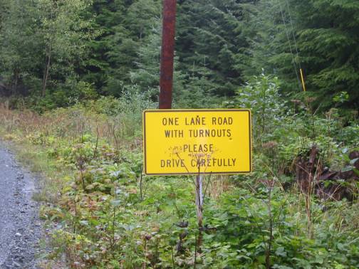 photo of a road sign: one lane road with turnouts please drive carefully