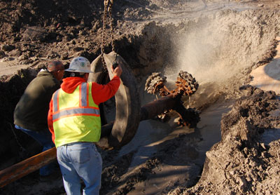 Workmen in a trench positioning equipment to begin boring