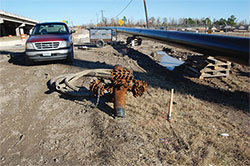 Photo showing drill bit used for boring and a length of conduit in a coil.