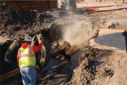 Workmen in a trench positioning equipment to begin boring.